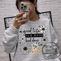 A Good Life Has Some Bad Days Too — encouraging good-life lettering surrounded by daisies
